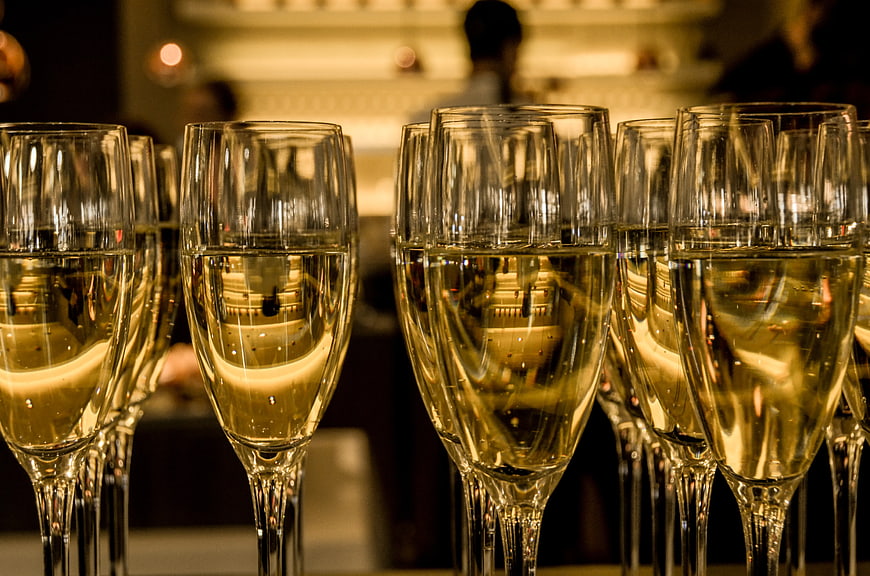 Rows of champagne flutes with golden liquid at a celebration