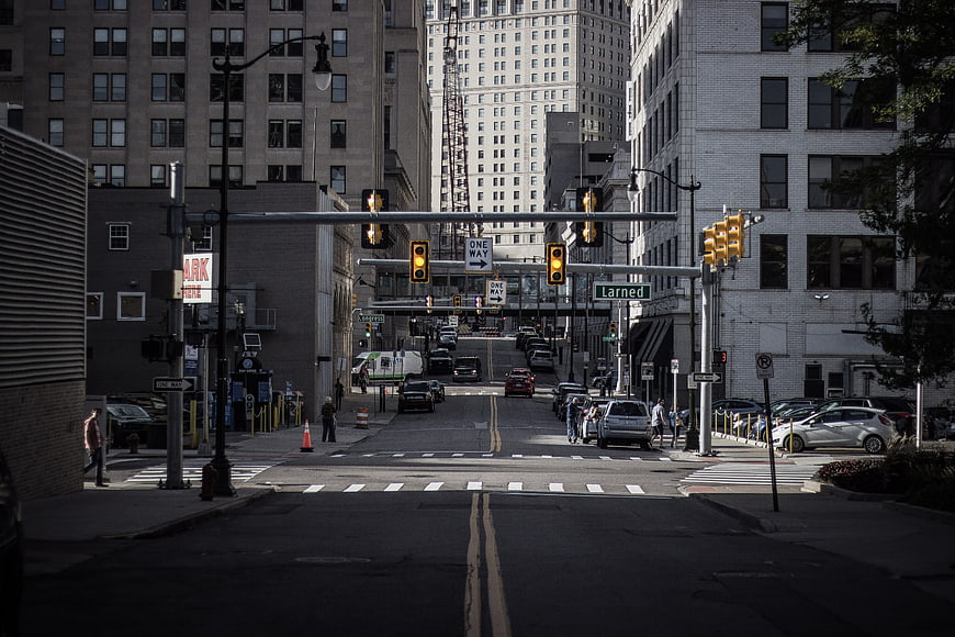 Urban Street Intersection With Traffic Lights And City Buildings