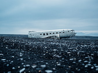 Crashed airplane fuselage on black sand beach in Iceland