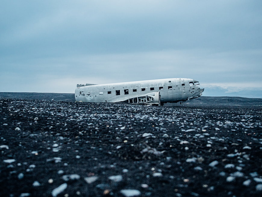 Crashed airplane fuselage on black sand beach in Iceland