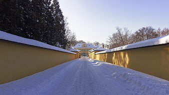Snowy path leading to yellow castle in winter