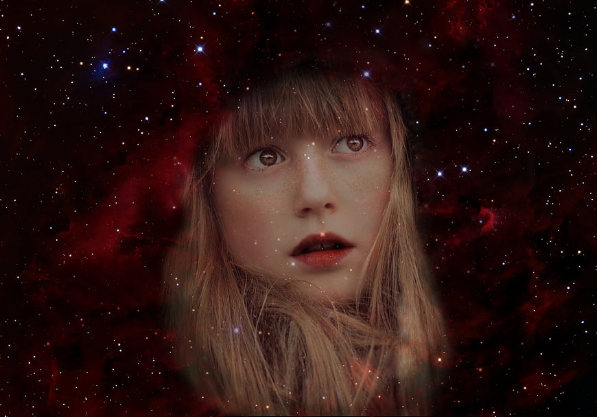 Fantasy girl face superimposed on red nebula starry sky