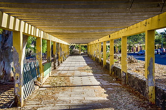 Yellow Covered Walkway with Peeling Paint and Leading Lines