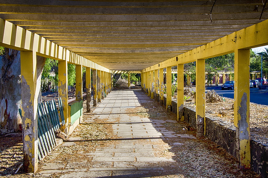 Yellow Covered Walkway with Peeling Paint and Leading Lines