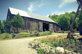 Weathered Old Wooden Barn With Metal Roof In Rural Farm Setting
