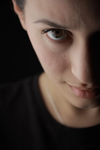 Close-up portrait of woman with intense gaze in shadow
