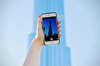Woman taking photo of Burj Khalifa with smartphone