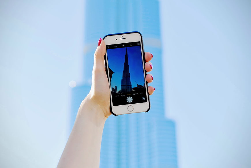 Woman taking photo of Burj Khalifa with smartphone