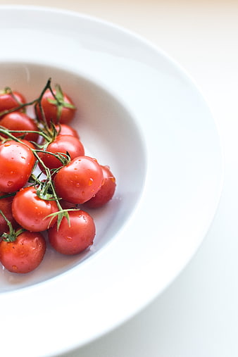 Fresh Red Cherry Tomatoes on Vine in White Bowl