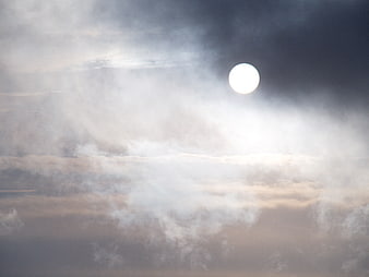 Bright Sun Shining Through Dramatic Clouds in Moody Sky