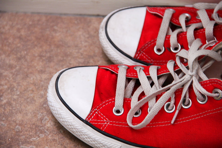 Close-up of red canvas sneakers on textured floor