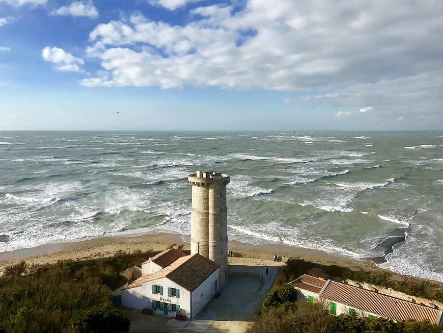 Aerial View of Historic Stone Lighthouse on Windy Coastline