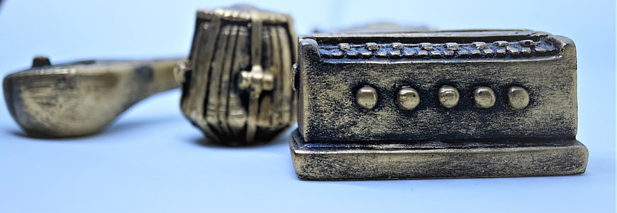 Close-up of vintage metal toy typewriter on blue background