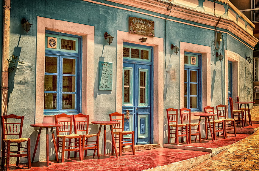 Colorful Mediterranean Cafe Facade with Red Chairs