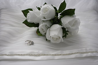 White Rose Bouquet and Wedding Rings on White Fabric