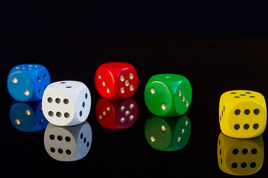 Colorful Dice on Black Reflective Surface