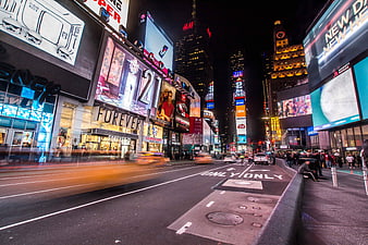 Night view of Times Square New York City with traffic and billboards
