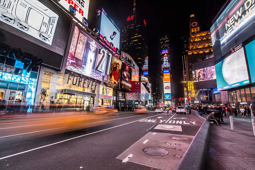 Night view of Times Square New York City with traffic and billboards