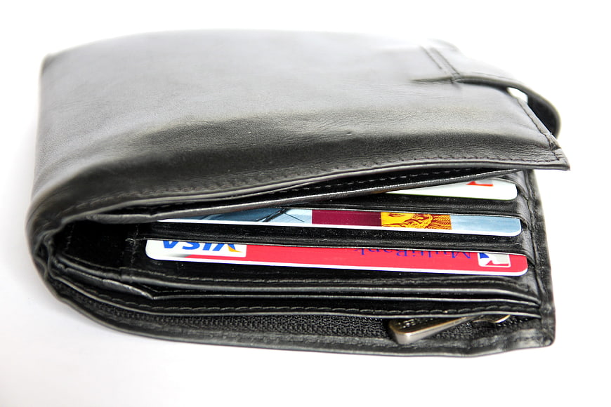 Black leather wallet with credit cards on white background