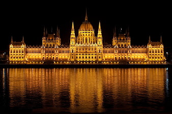Illuminated Hungarian Parliament Building at Night with River Reflection