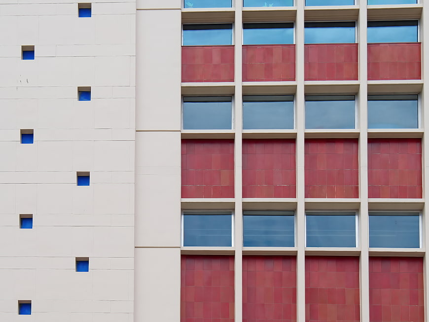 Modern Building Facade with Red Tiles and Blue Windows