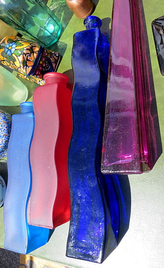 Colorful Wavy Glass Bottles on Green Surface