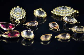 Gold Crystal Jewelry Pendants On Black Reflective Surface