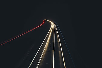 Abstract light trails on a dark highway at night