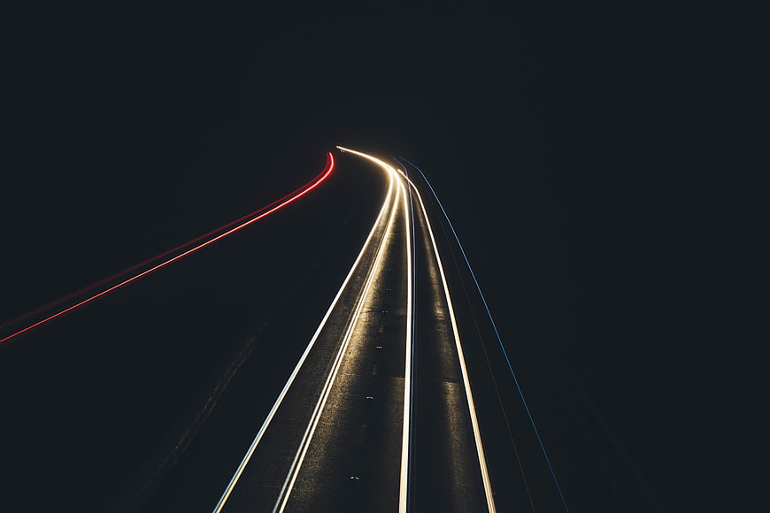 Abstract light trails on a dark highway at night