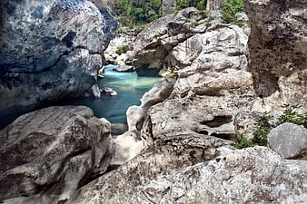 Rocky River Canyon With Turquoise Water And Lush Vegetation