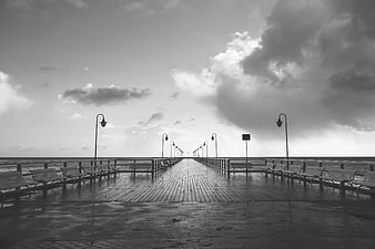 Empty Wooden Pier at Sea with Dramatic Clouds