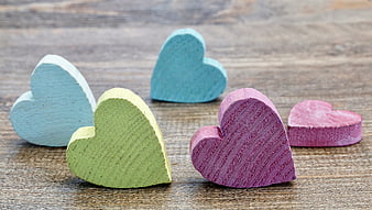 Colorful Wooden Hearts on Rustic Wood Background