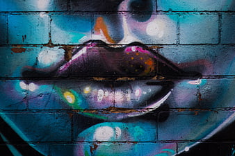 Colorful graffiti lips on textured blue brick wall