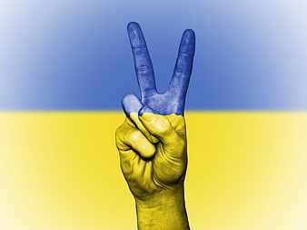 Hand with peace sign painted in Ukrainian flag colors