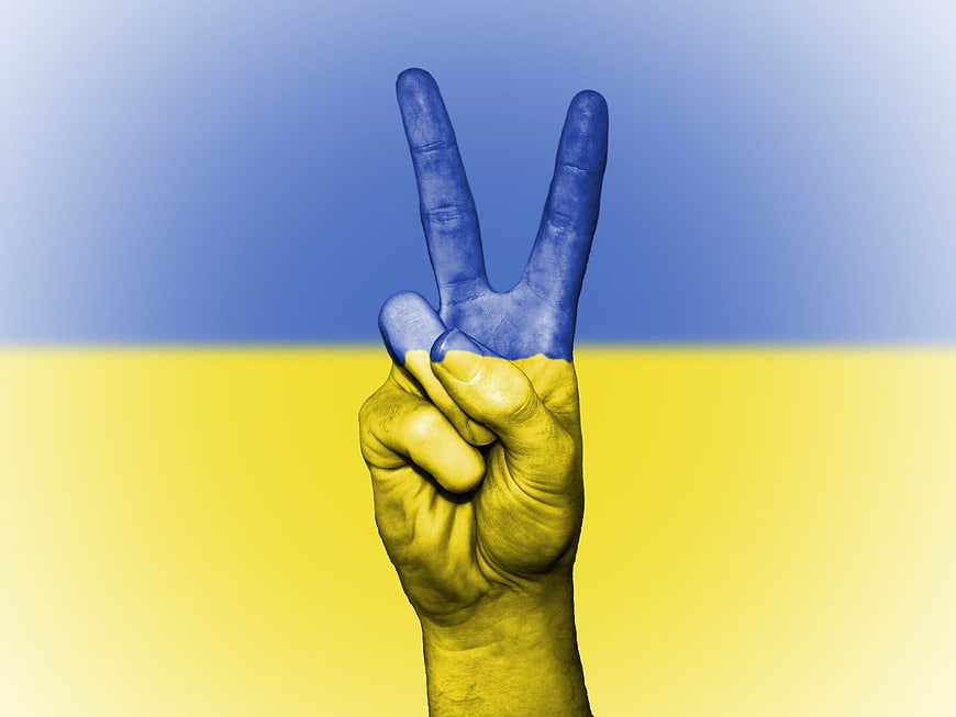 Hand with peace sign painted in Ukrainian flag colors