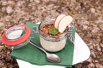 Healthy yogurt parfait with granola and apple slices in glass jar