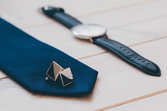 Blue Tie, Cufflinks, and Watch on Wooden Surface