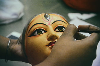 Close-up of artisan painting traditional Indian mask