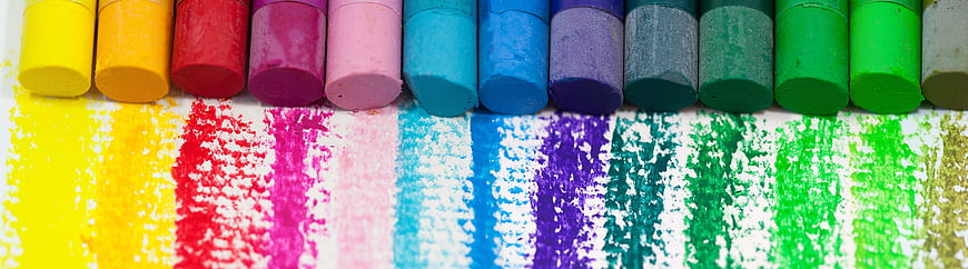 Colorful oil pastels with vibrant rainbow strokes on white paper