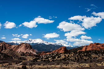 Snow-capped mountain range behind red rock formations