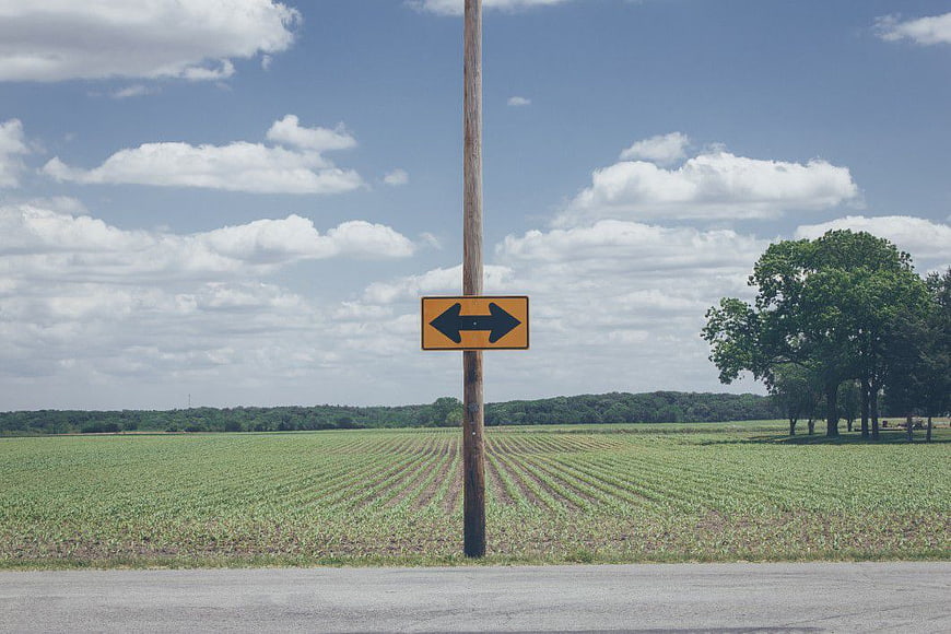 Yellow Double Arrow Road Sign in Rural Cornfield