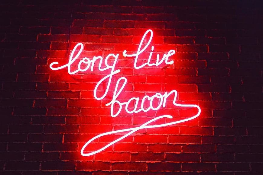 Red Neon Sign Saying Long Live Bacon on Brick Wall