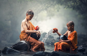 Young Buddhist Monks Washing Alms Bowls in Misty River