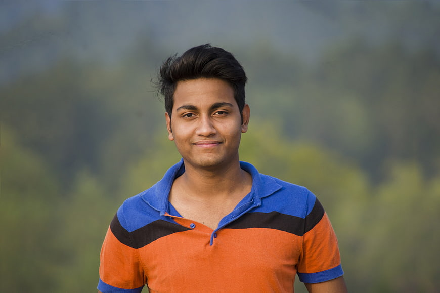 Portrait of a smiling young man in a colorful polo shirt outdoors