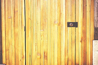 Close-up of yellow wooden fence with black keyhole