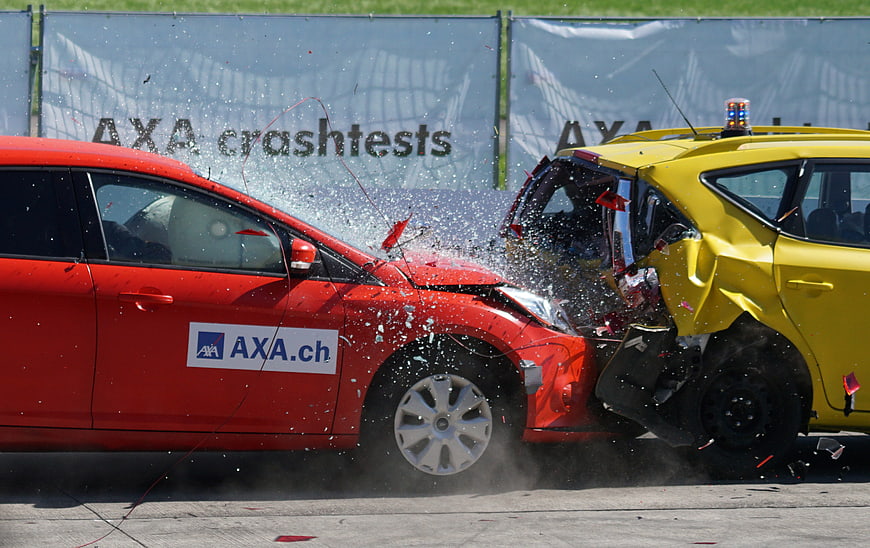 Red and yellow cars colliding in a crash test demonstration