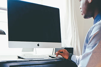 Man Working on iMac Computer at Desk