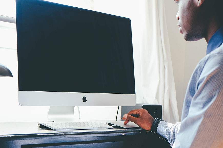 Man Working on iMac Computer at Desk