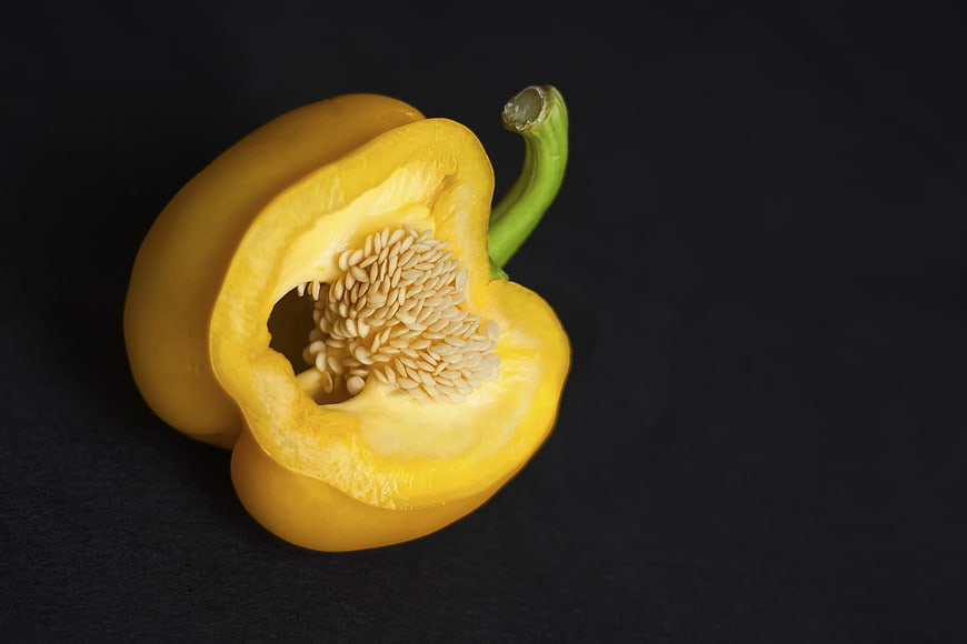 Sliced Yellow Bell Pepper with Seeds on Black Background