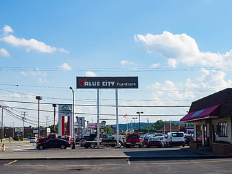 Value City Furniture Sign and Car Dealership on Highway
